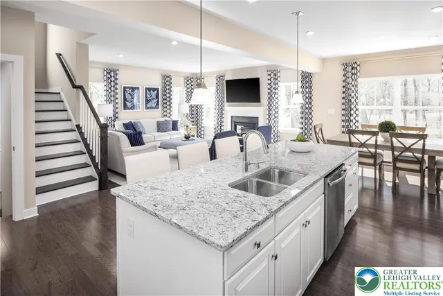 a kitchen with granite countertop a sink a counter top space and living room view