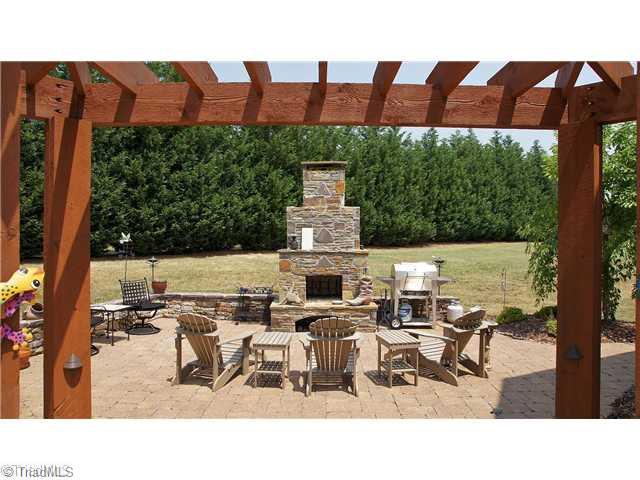 5617 Foxbury Drive Oak Ridge, NC 27310 - Photo 14 of 15 Patio/Deck. Stamped Concrete & Brick Patio w/Outdoor Stone Fireplace Surrounded by Cedar Trellis