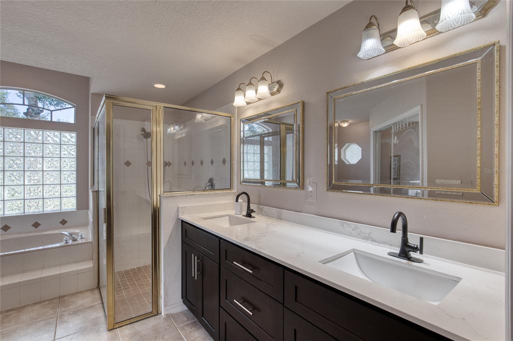 4 Cliffside Drive Ormond Beach, FL 32174 - Photo 17 of 65 a bathroom with a double vanity sink a mirror and a bathtub