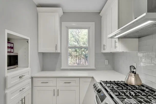 a kitchen with white cabinets and appliances