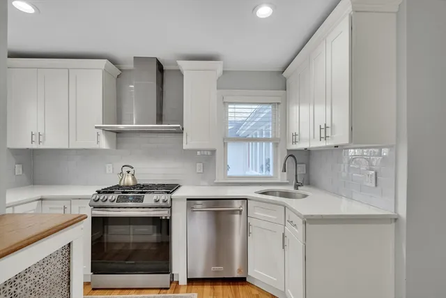 a kitchen with white cabinets stainless steel appliances and sink