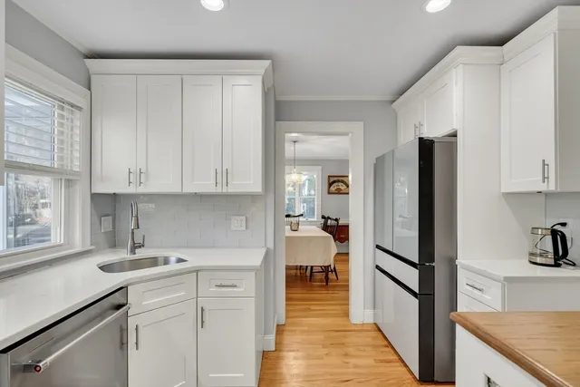 a kitchen with white cabinets and sink