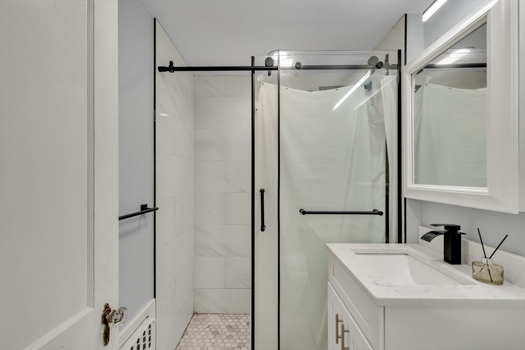 33 Avon Road Wellesley, MA 02482 - Photo 31 of 35 a bathroom with a shower sink vanity and mirror