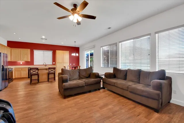 a kitchen with stainless steel appliances granite countertop wooden floor dining table and chairs