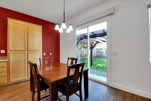 a view of a dining room with furniture a kitchen and chandelier