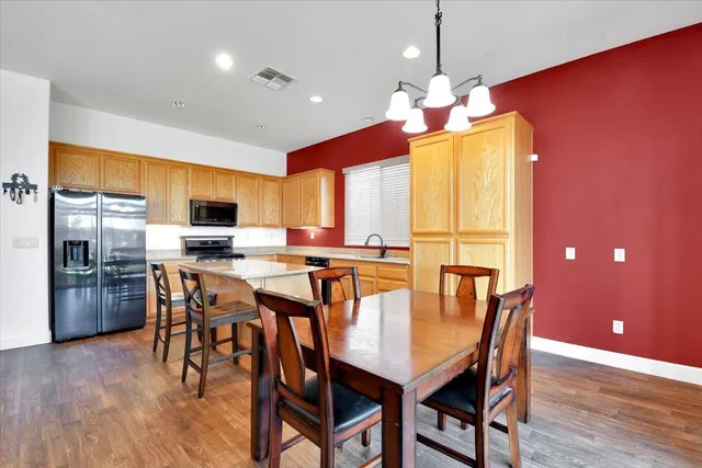 a dining room with furniture a chandelier and wooden floor