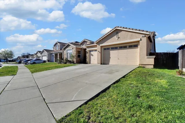 a front view of a house with a garden and yard