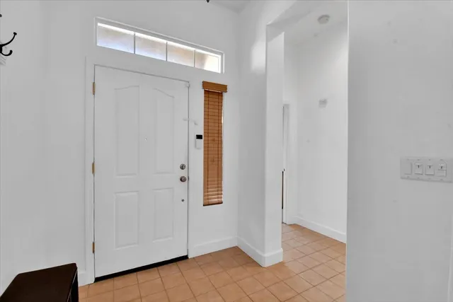 a view of a hallway with wooden floor and a living room