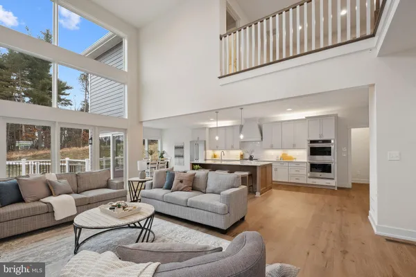 a living room with furniture and a dining table with kitchen view