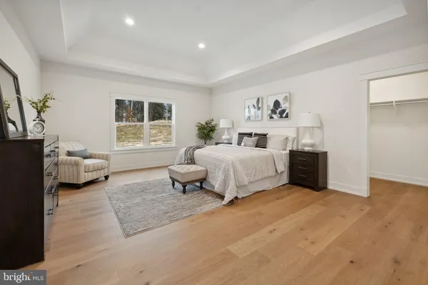 a spacious bedroom with a bed a couch and a window