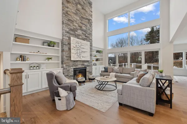 a living room with furniture a fireplace and a large window