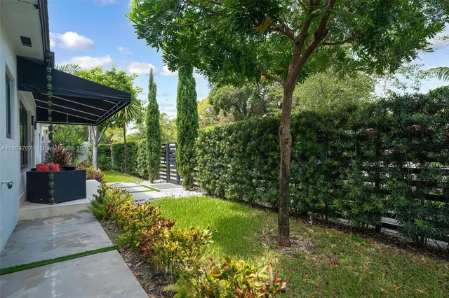 a living room with patio furniture and a potted plant