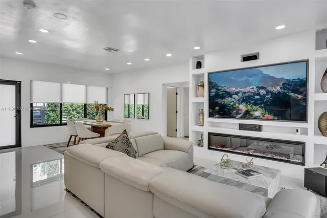 a living room with furniture kitchen view and a potted plant