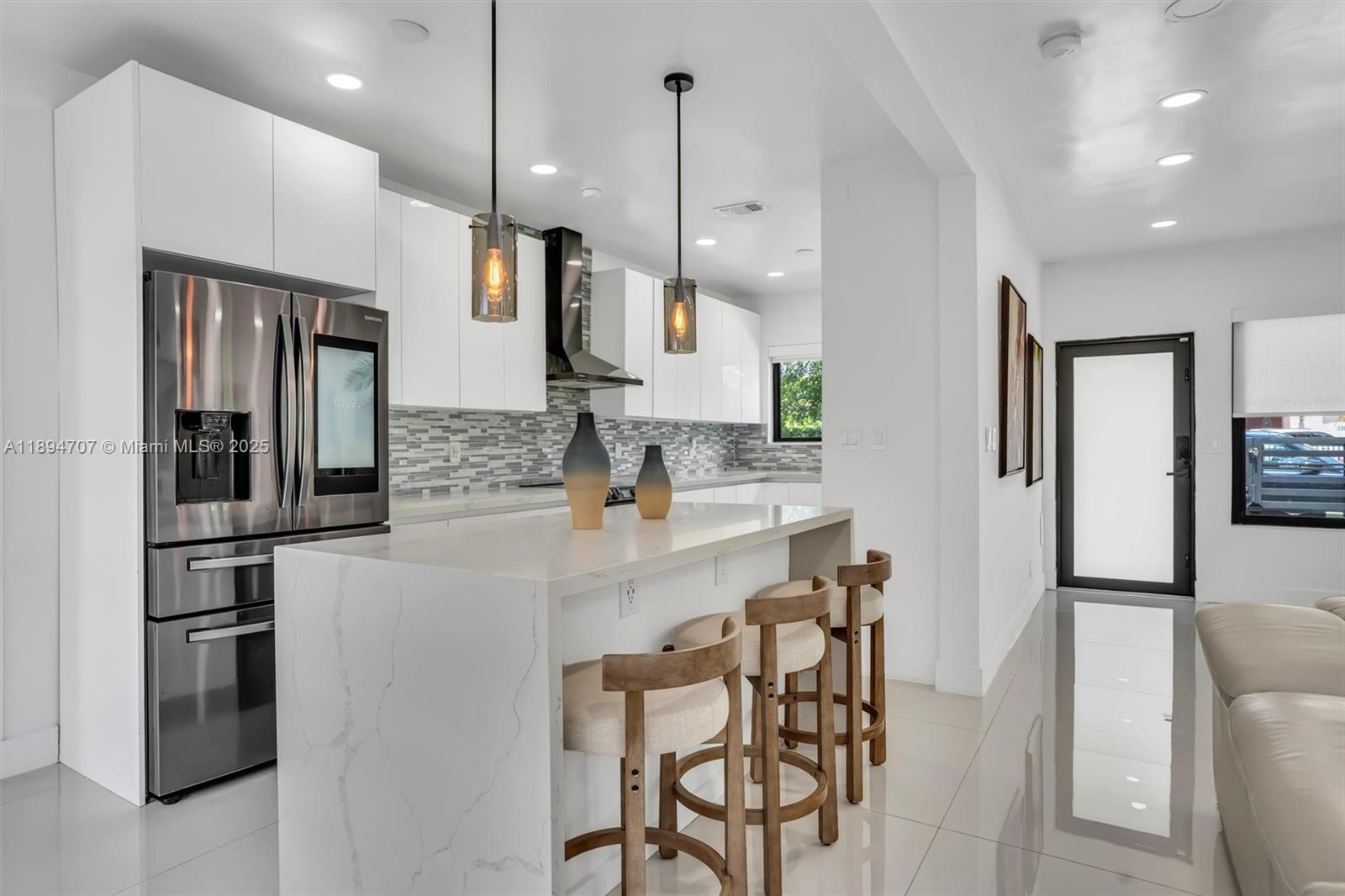 2484 Southwest 25th Street Miami, FL 33133 - Photo 22 of 53 a kitchen with stainless steel appliances kitchen island granite countertop a refrigerator a sink a stove and chairs with wooden floor