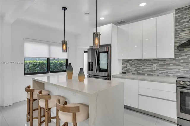 a kitchen with stainless steel appliances granite countertop a sink a stove and a refrigerator