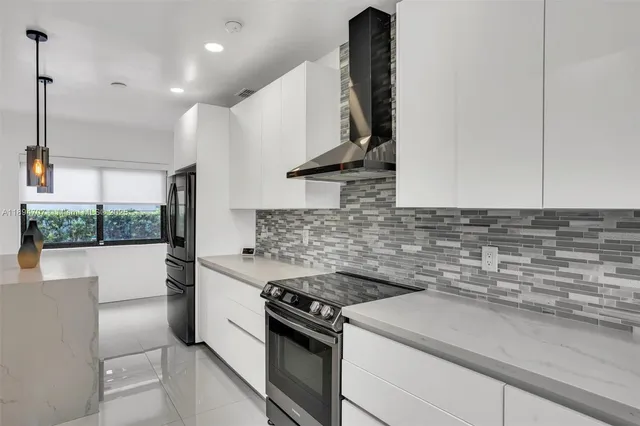 a view of kitchen with stainless steel appliances granite countertop refrigerator sink and wooden floor