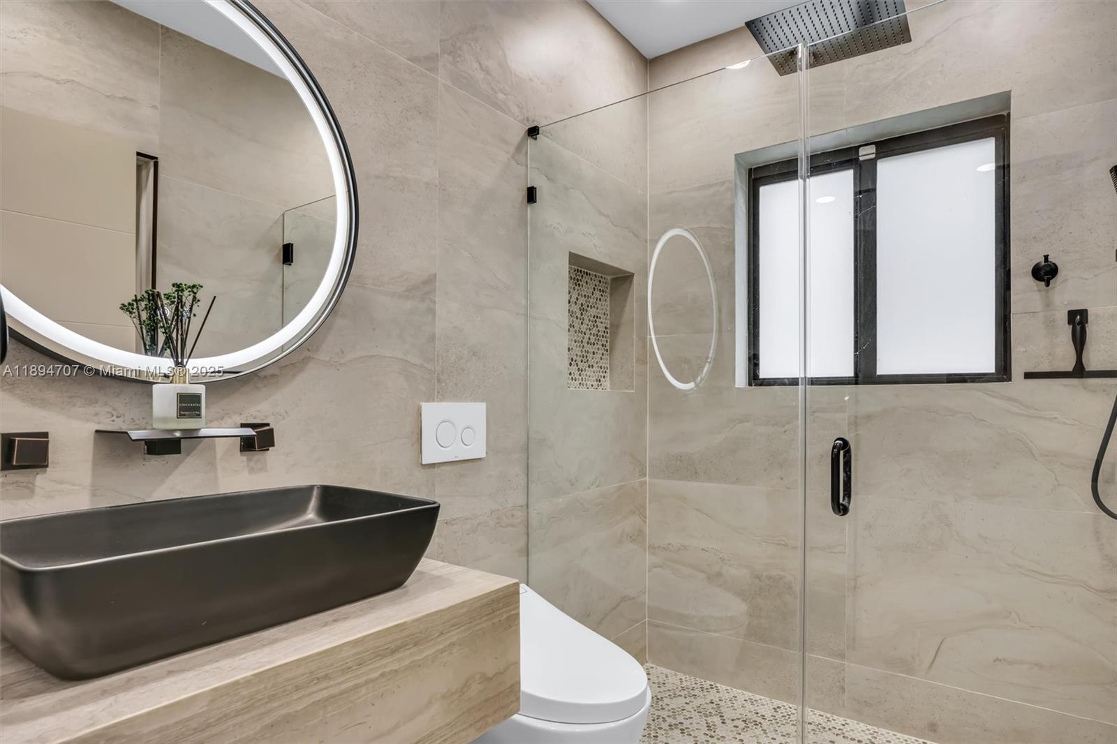 2484 Southwest 25th Street Miami, FL 33133 - Photo 39 of 53 a bathroom with a sink a toilet and a mirror