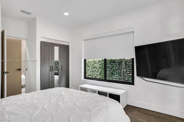 a bed sitting in a bedroom next to a window