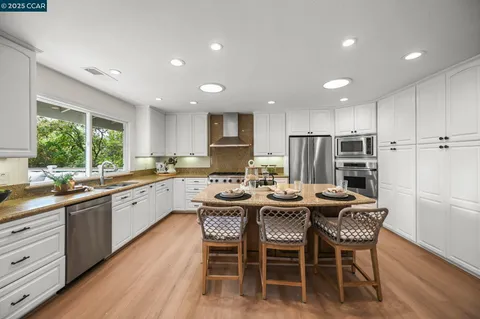 a large kitchen with kitchen island a dining table and chairs