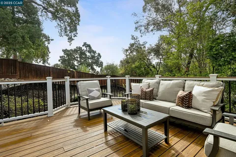 a roof deck with couches and wooden floor