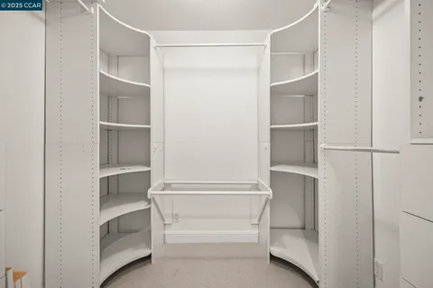 a walk in closet with white walls