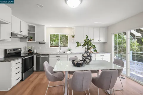 a view of a dining room with furniture a potted plant and wooden floor