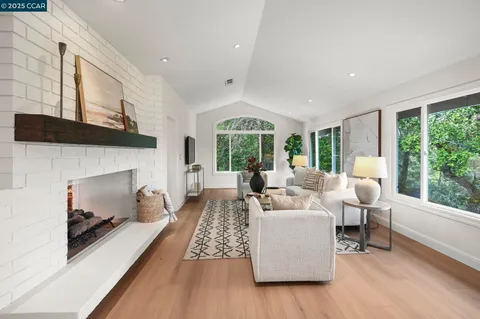 a living room with furniture fireplace and large windows