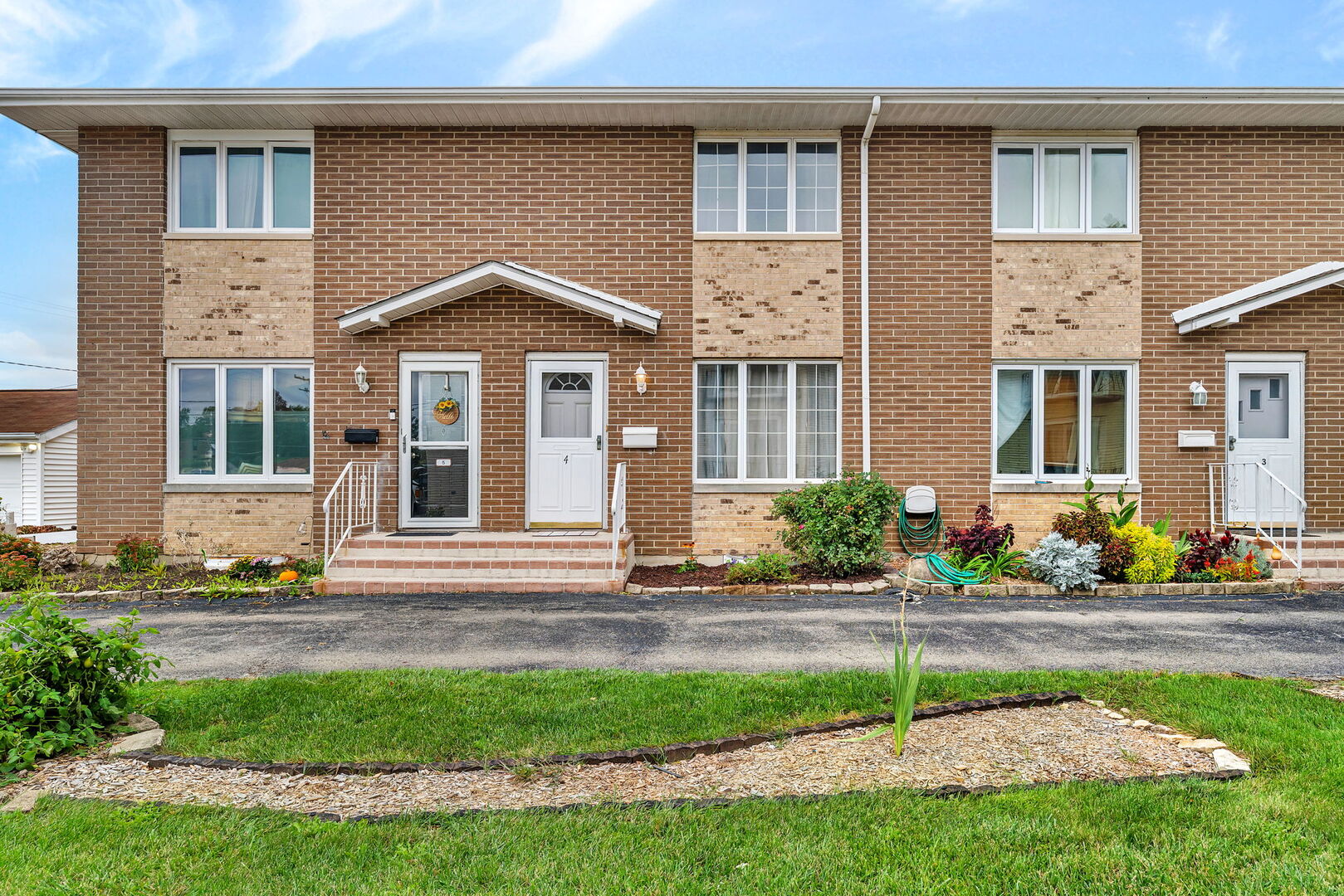 613 East 3rd Street, Unit 4 Lockport, IL 60441 - Photo 1 of 25 a front view of a house with a yard and many windows