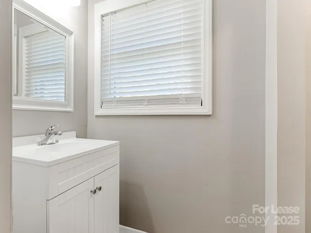 a bathroom with a sink vanity and a window