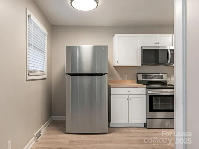 a kitchen with a refrigerator and a stove