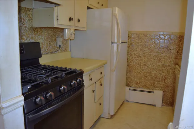 a kitchen with white cabinets and white appliances