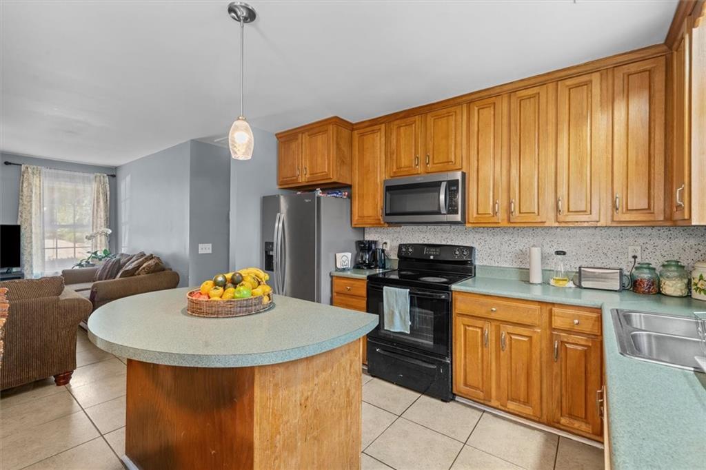 171 Bear Den Court Dalton, GA 30721 - Photo 12 of 30 a kitchen with stainless steel appliances granite countertop a sink a stove and refrigerator