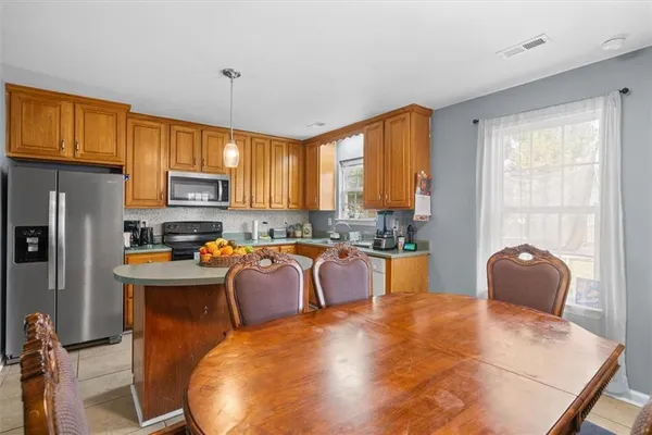 a large kitchen with sink a refrigerator and wooden cabinets