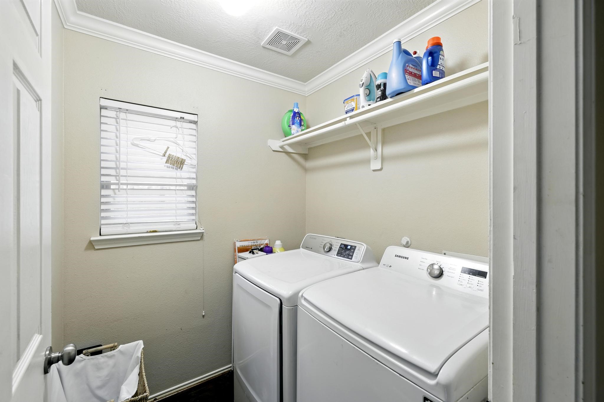 3002 Trinity Pass Court Spring, TX 77373 - Photo 11 of 22 Convenient interior utility room with upper shelving, full-size washer and dryer connections, and natural light from window.