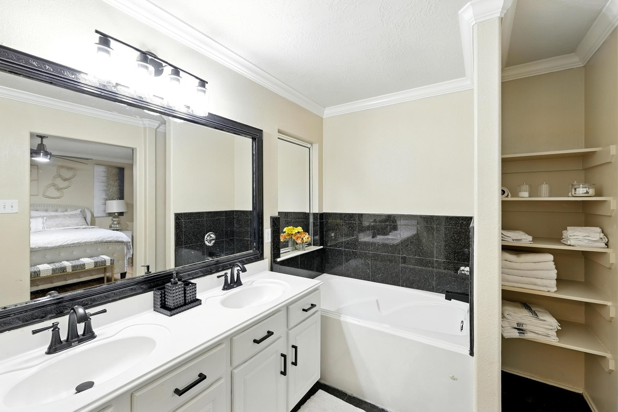 3002 Trinity Pass Court Spring, TX 77373 - Photo 17 of 22 Relax in the deep soaking tub surrounded by sleek black tile. Built-in shelving and extended counter space provide stylish functionality.