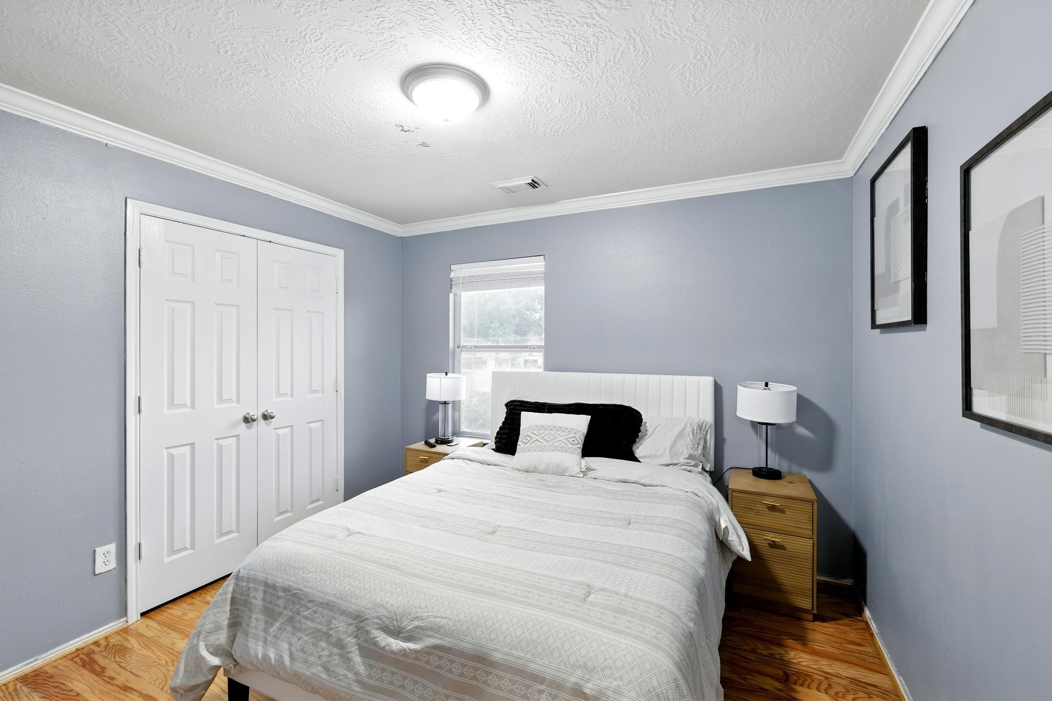 3002 Trinity Pass Court Spring, TX 77373 - Photo 20 of 22 Spacious secondary bedroom with calming blue tones, double-door closet, crown molding, and large window providing abundant natural light.