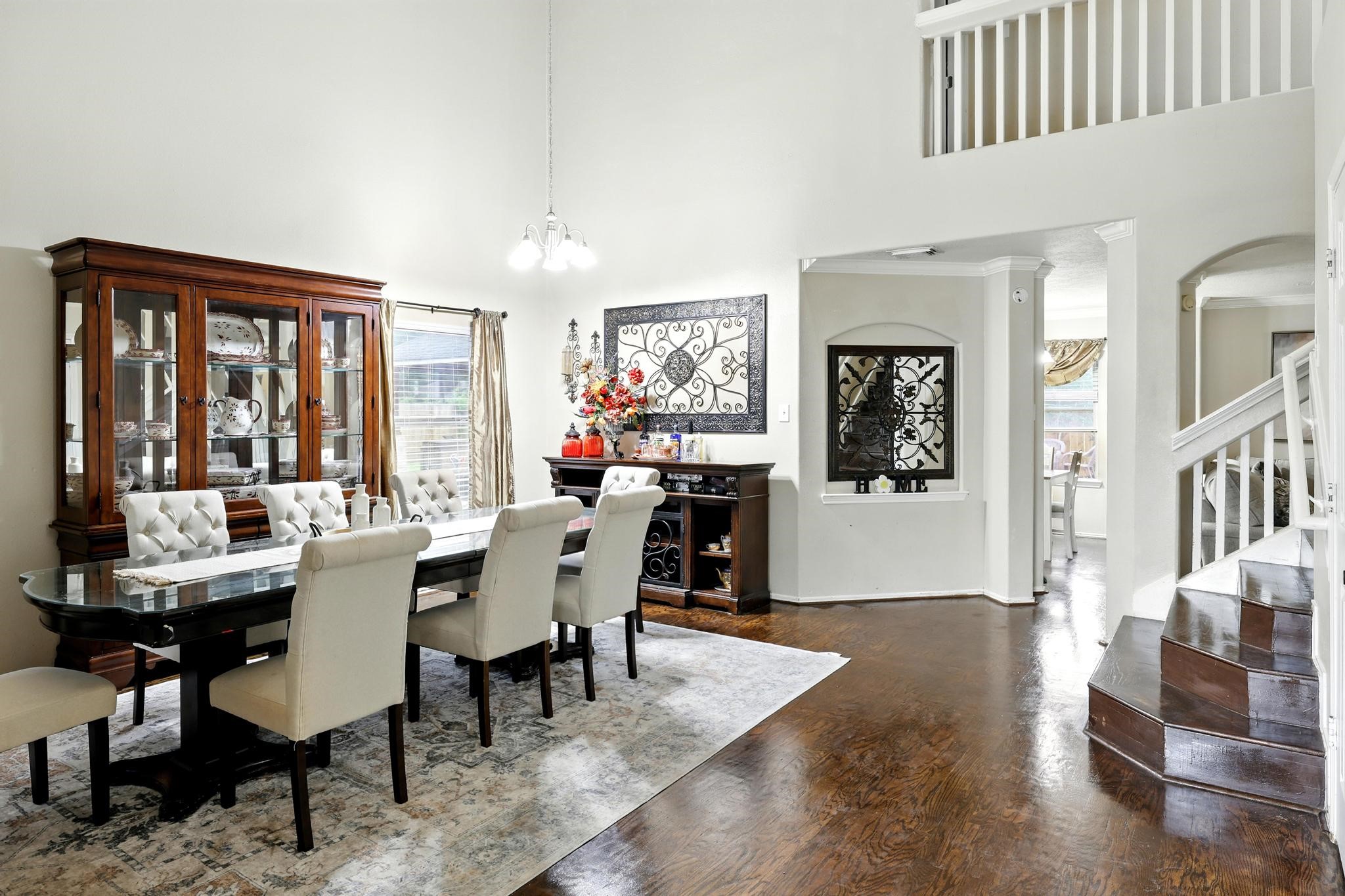 3002 Trinity Pass Court Spring, TX 77373 - Photo 3 of 22 Elegant formal dining area with soaring ceilings, wood flooring, and views into the open-concept layout. Accented by arched openings and crisp crown molding for a refined feel.