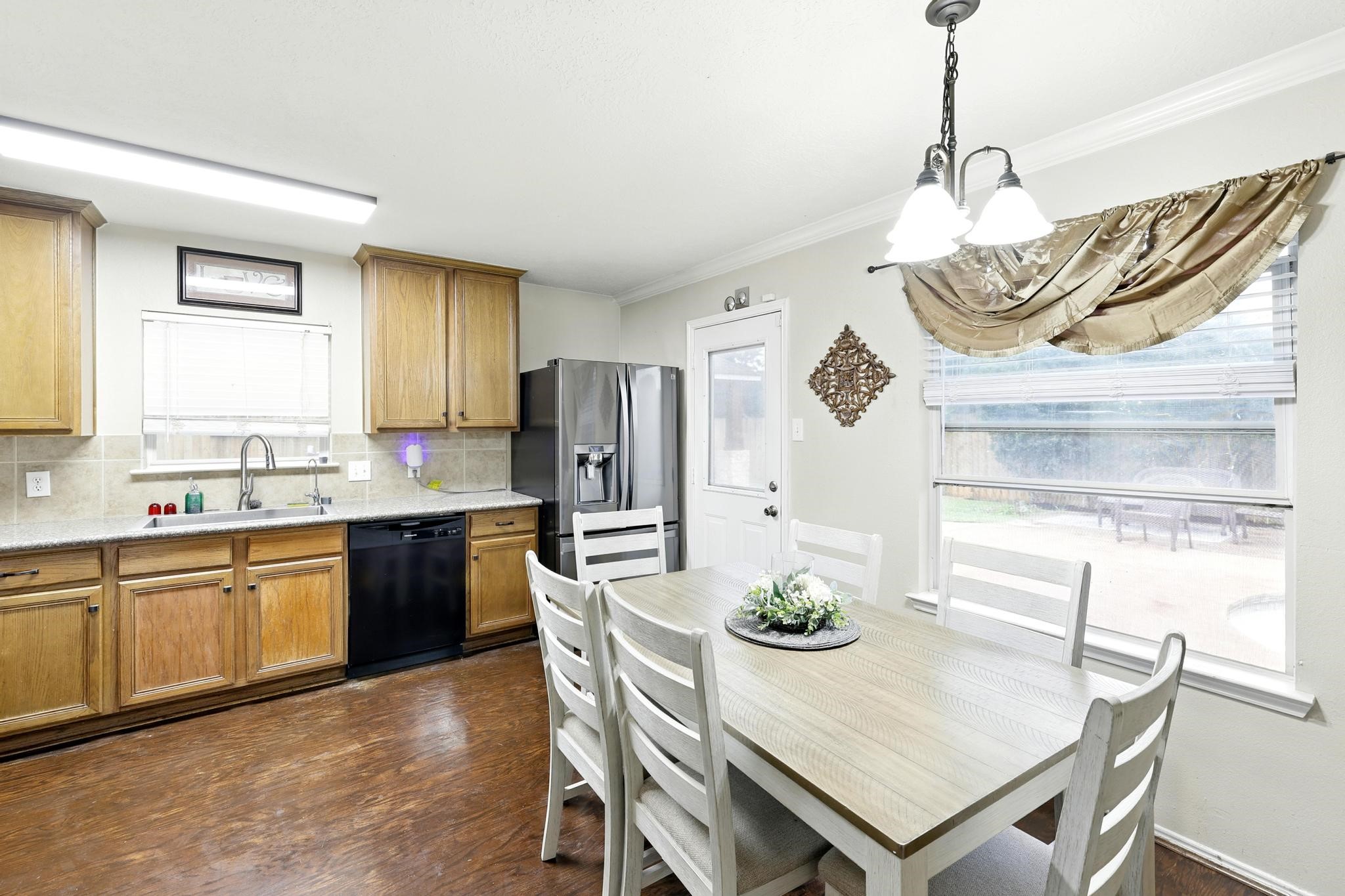 3002 Trinity Pass Court Spring, TX 77373 - Photo 6 of 22 Bright and airy eat-in kitchen with large windows, backyard views, and direct patio access, perfect for casual dining and entertaining.