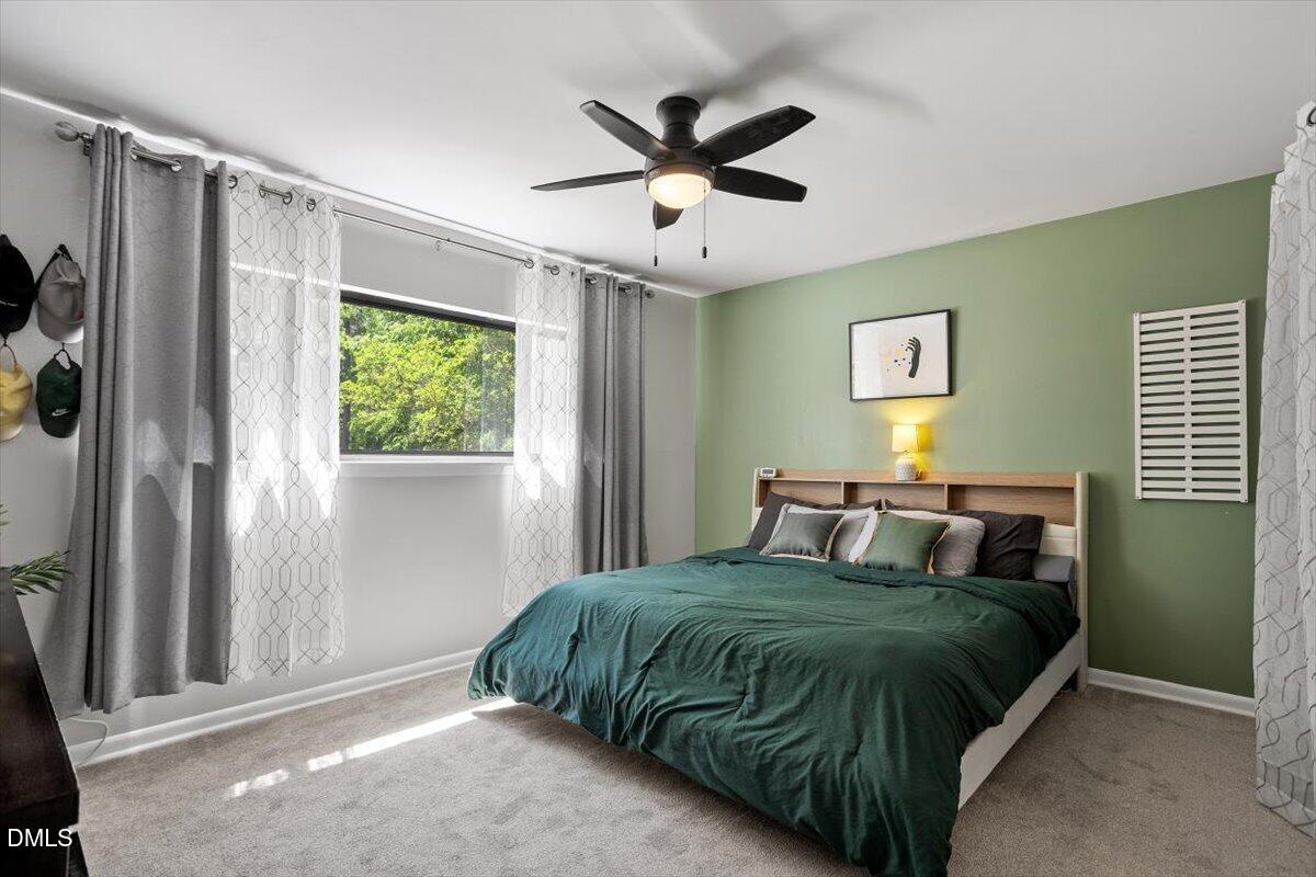 5045 Tall Pines Court Raleigh, NC 27609 - Photo 20 of 37 a bedroom with a bed window and a ceiling fan
