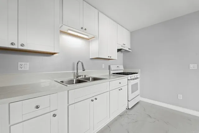 a kitchen with white cabinets and a sink