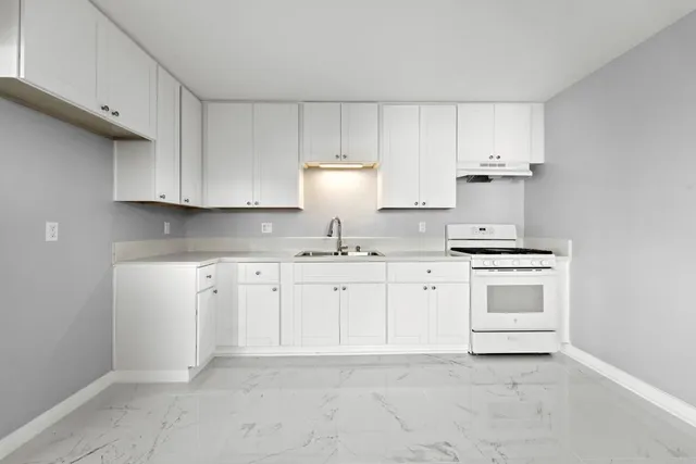 a kitchen with granite countertop white cabinets and white appliances