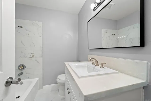 a bathroom with a sink a toilet and mirror