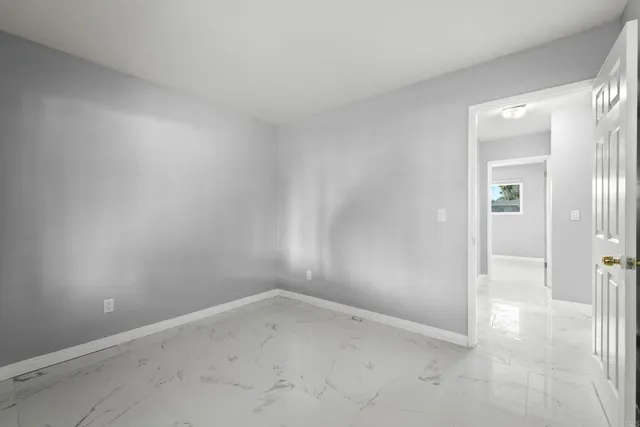 an empty room with windows and entrance to other room