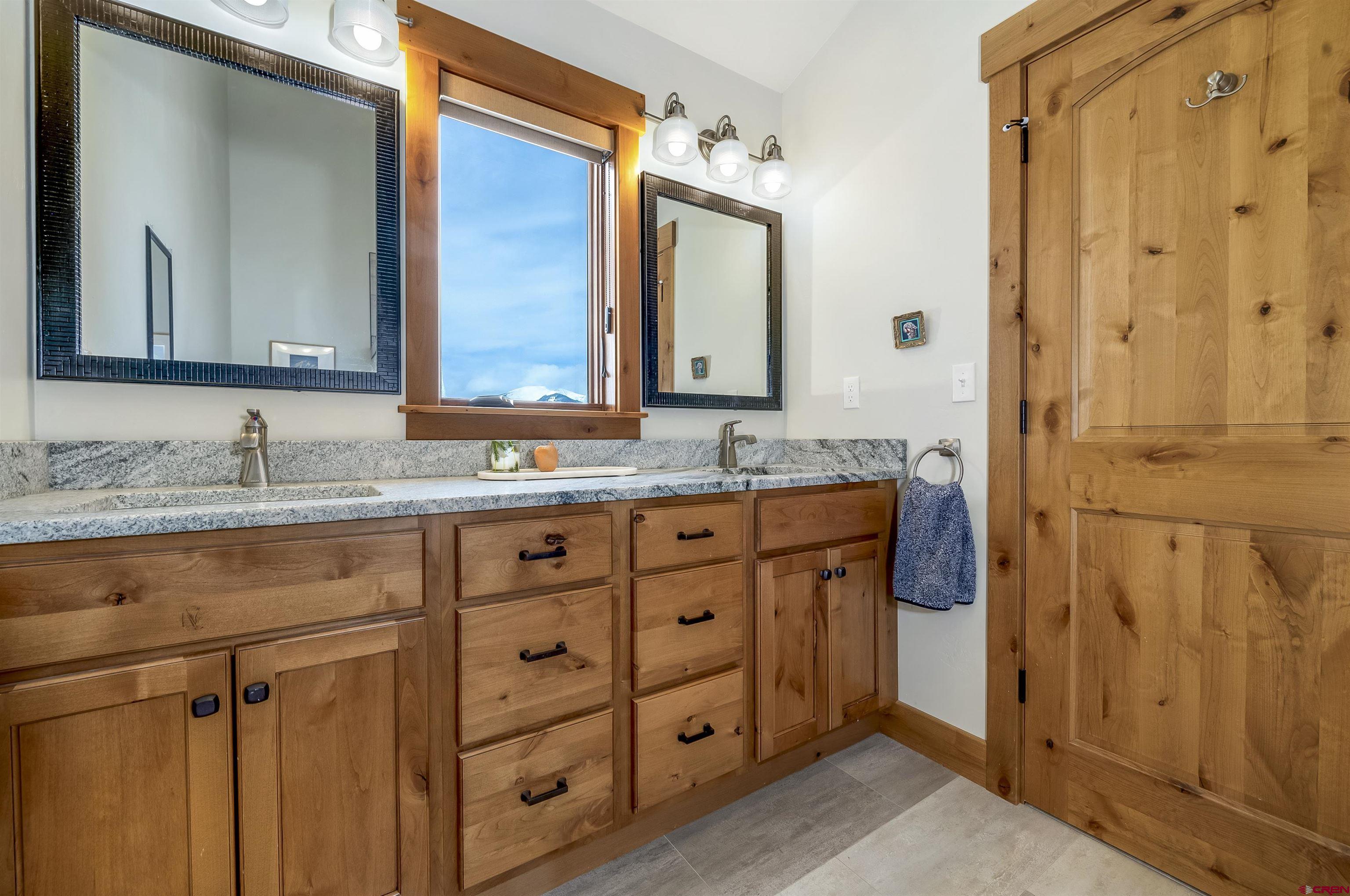 48 Elk Valley Road, Unit B Crested Butte, CO 81224 - Photo 14 of 34 a bathroom with a granite countertop sink and a mirror