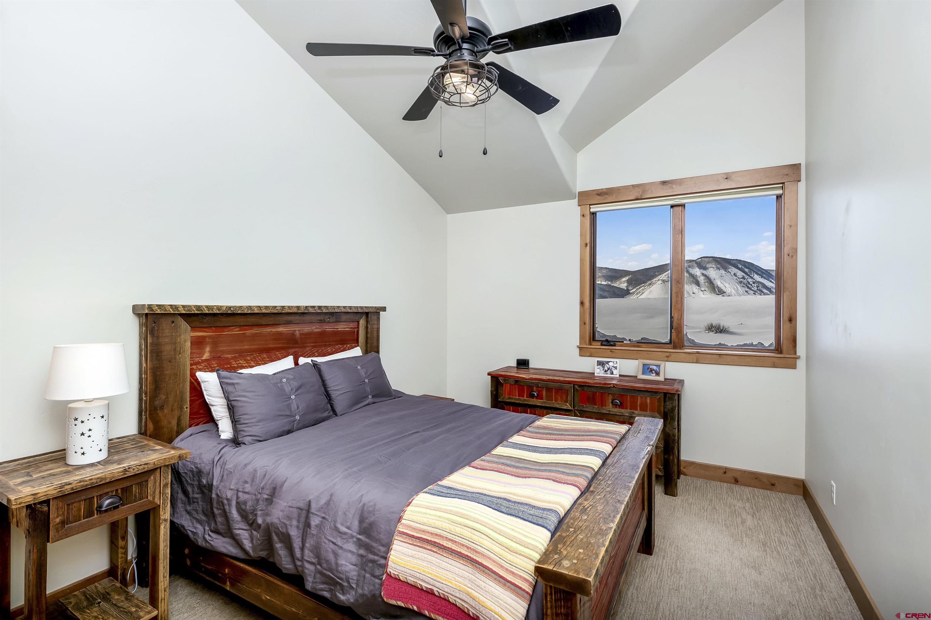 48 Elk Valley Road, Unit B Crested Butte, CO 81224 - Photo 17 of 34 a bedroom with a bed and a chandelier