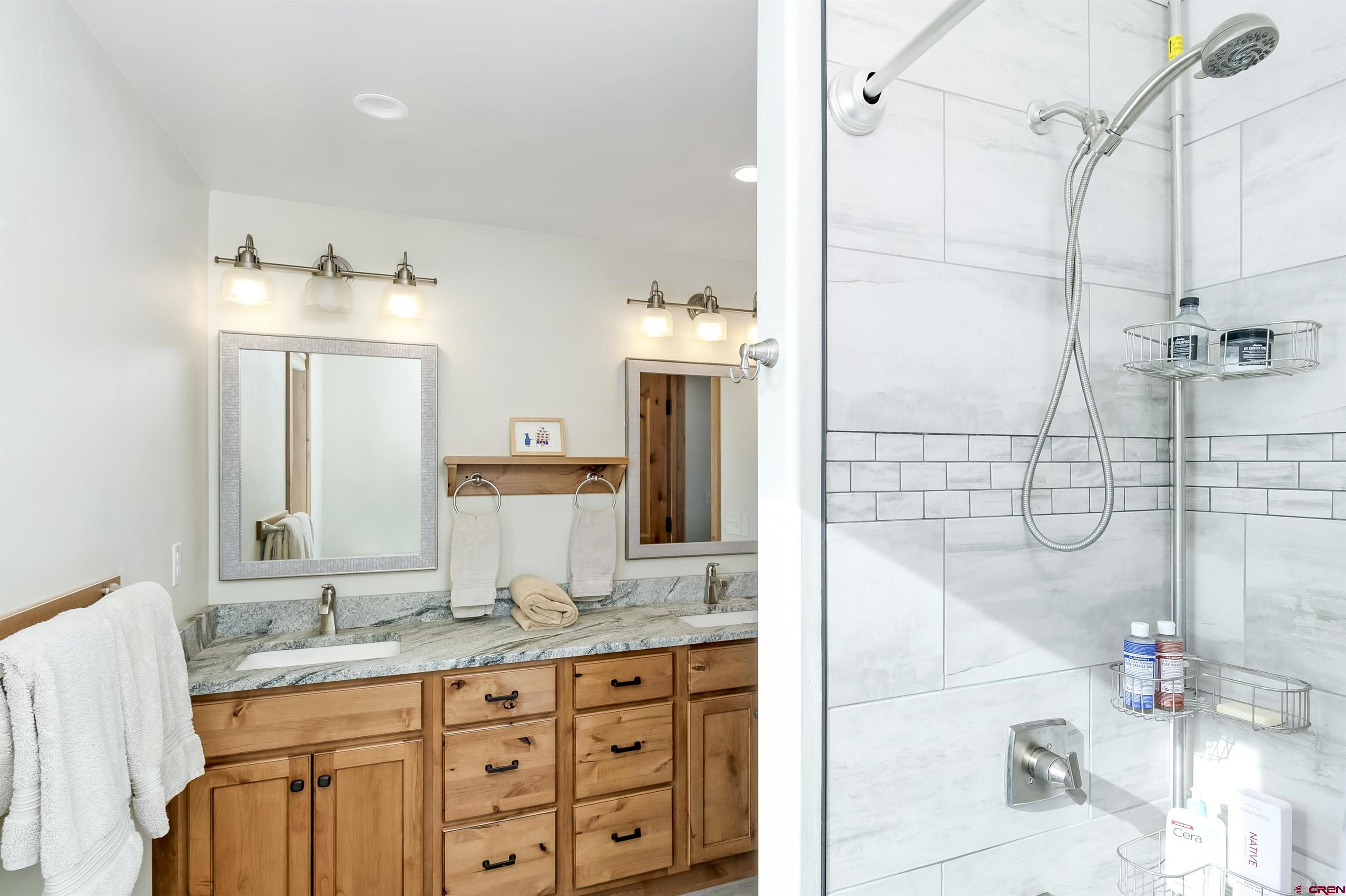48 Elk Valley Road, Unit B Crested Butte, CO 81224 - Photo 20 of 34 a bathroom with a granite countertop sink a mirror and shower