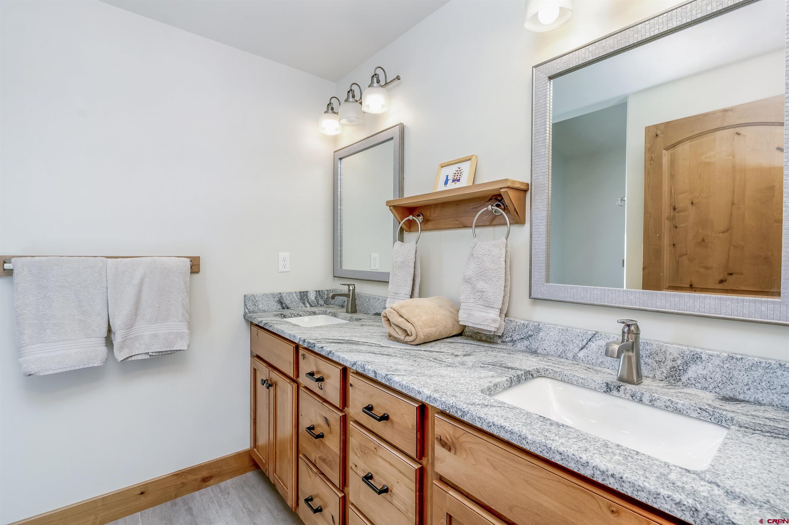 48 Elk Valley Road, Unit B Crested Butte, CO 81224 - Photo 21 of 34 a bathroom with a granite countertop sink and a mirror