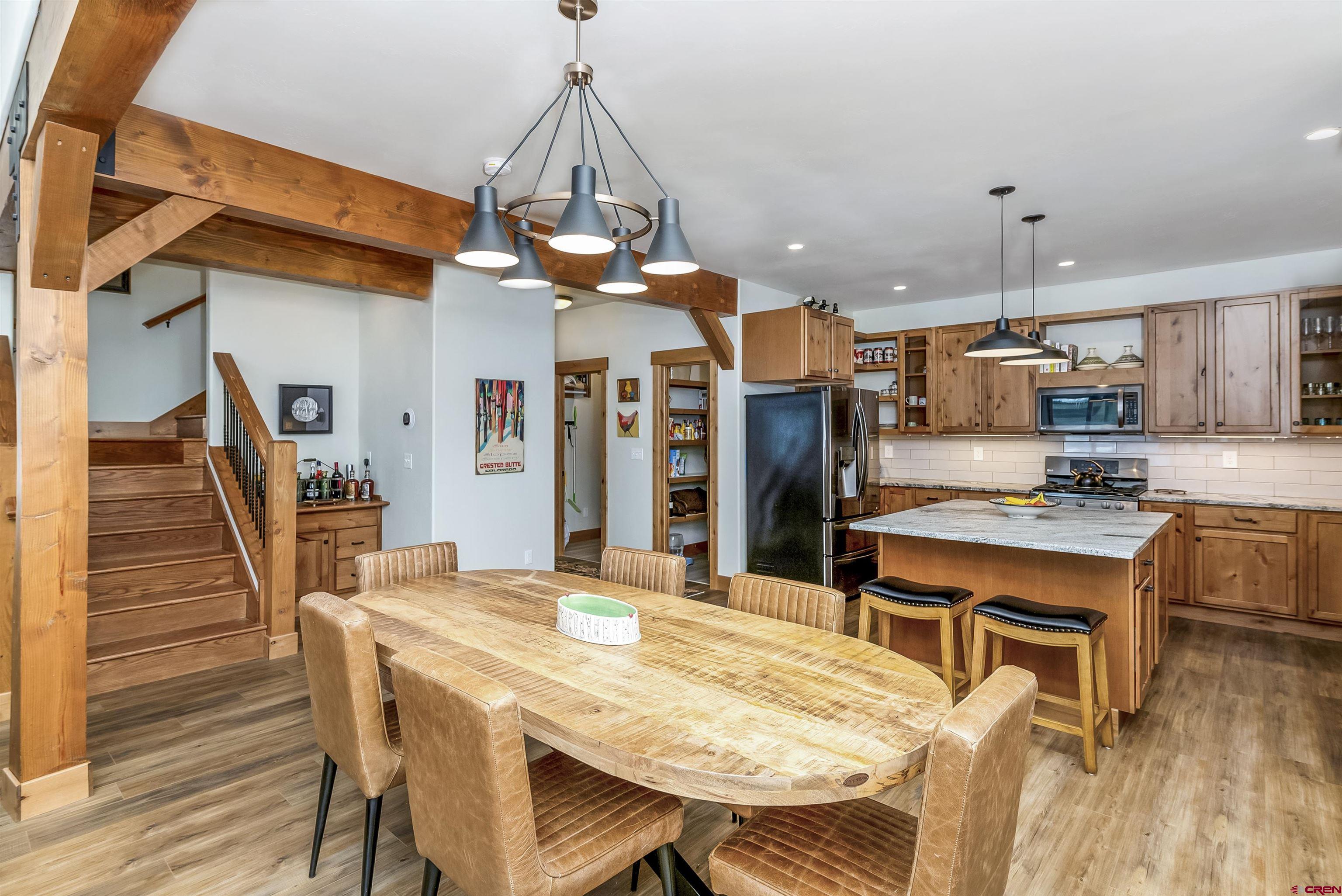 48 Elk Valley Road, Unit B Crested Butte, CO 81224 - Photo 6 of 34 a dining room with stainless steel appliances kitchen island granite countertop furniture and wooden floor