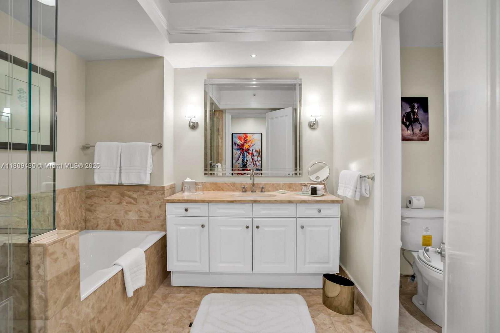 1435 Brickell Avenue, Unit 3012 Miami, FL 33131 - Photo 29 of 73 a bathroom with a granite countertop bathtub a sink and a mirror