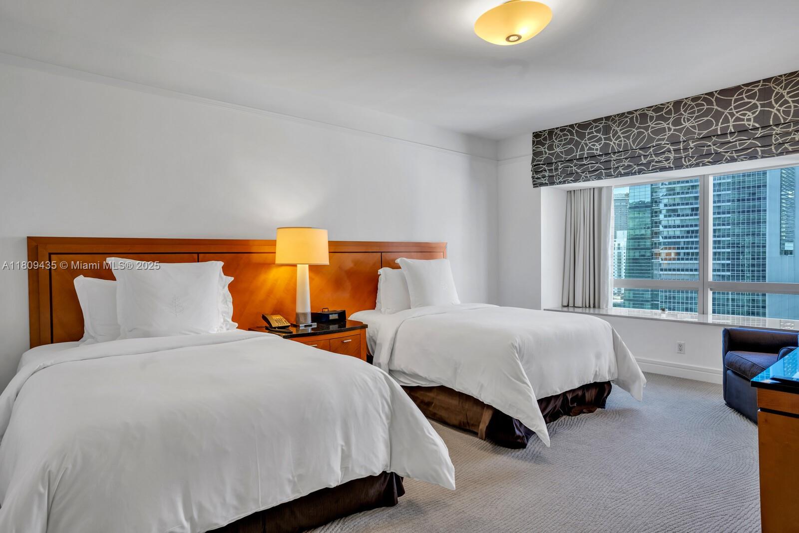 1435 Brickell Avenue, Unit 3012 Miami, FL 33131 - Photo 33 of 73 a bedroom with two beds and a window
